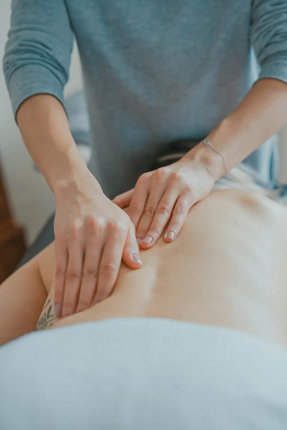 A therapist working one-on-one with a patient in a calm, light-filled clinic