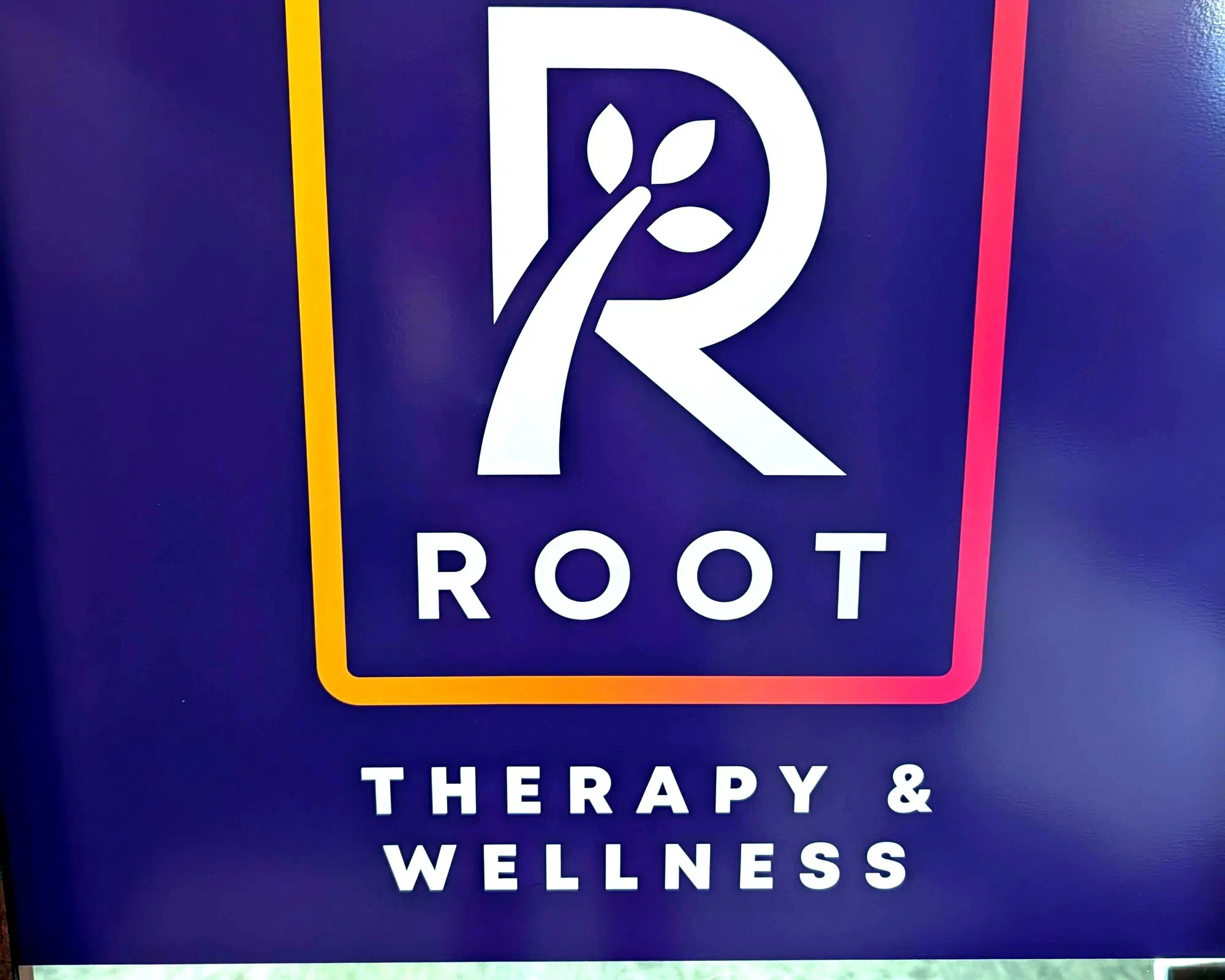 Root Therapy and Wellness lobby wall with the Root logo in Bozeman, Montana