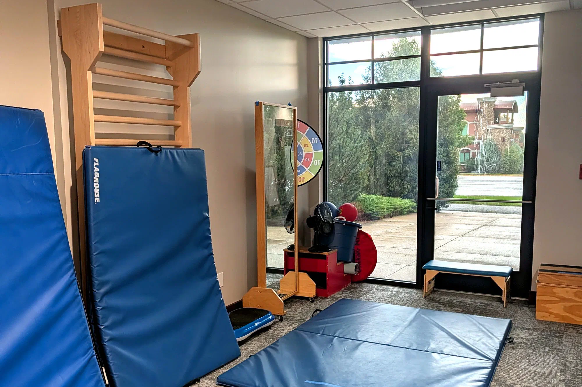 Pediatric therapy gym with climbing wall bars and padded mats at Root Pediatrics in Bozeman, Montana